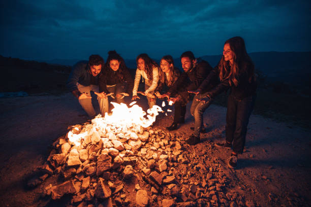 istock Happy group of friends in a circle around a bonfire 1470034391