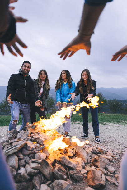istock Happy group of friends in a circle around a bonfire 1470034408