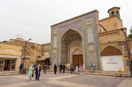 Shiraz, Iran – May 06, 2022: An archway decorated with tile mosaics marks the main entrance to Vakil Mosque in central Shiraz, Iran.