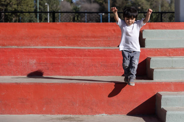 three year old mexican boy playing and jumping the stairs