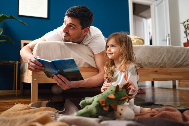 istock Story Time: Dad Reading a Book for His Daughter in the Morning 1470035393