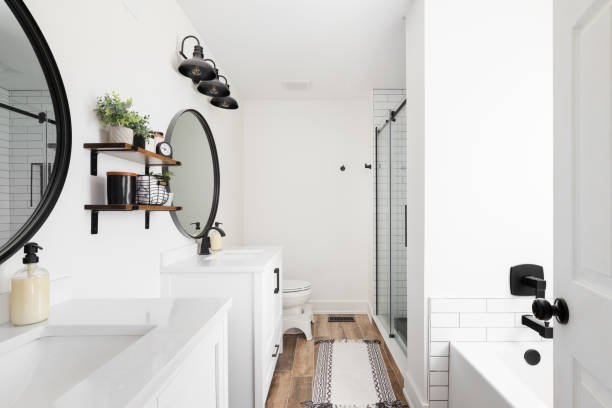 istock A farmhouse bathroom with white cabinets and circular mirrors. 1470035498