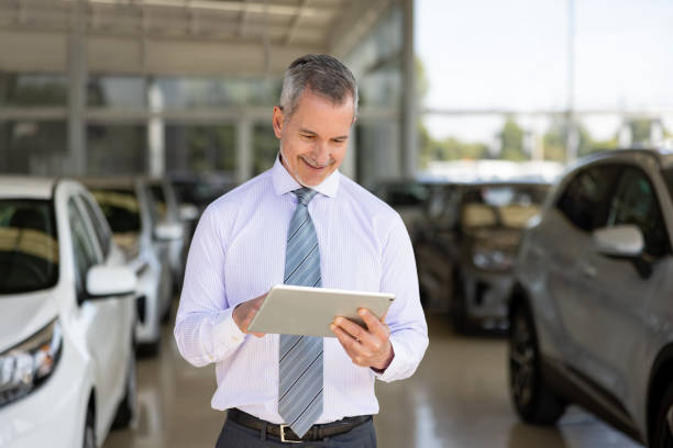 istock Car salesperson working at the dealership using a tablet 1470035731