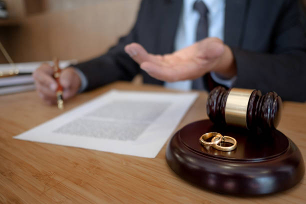 istock Judge gavel with marriage ring working with divorce contract. 1470035791