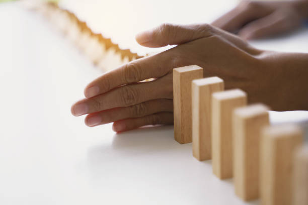 istock Risk management, female hand protecting wooden brick, Stop problem in business concept. 1470035848