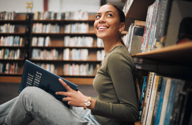 istock Student, thinking and reading books library floor for knowledge, college education and research planning. University bookshop, young girl learning and happy vision for  scholarship or study for exam 1470038800