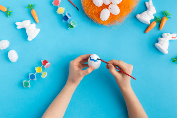 istock easter white rabbits ready to paint carrots concept hands 1470045770