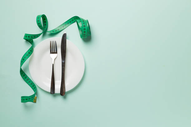 istock Green tape measure with plate on color background, top view 1470046708