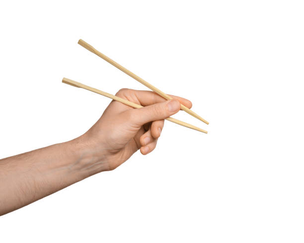 istock Bamboo sticks for sushi in male hand, isolate on white 1470047138