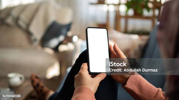 Woman Using Phone With White Screen While Lying On Sofa At Home Mock Up Screen Stock Photo - Download Image Now