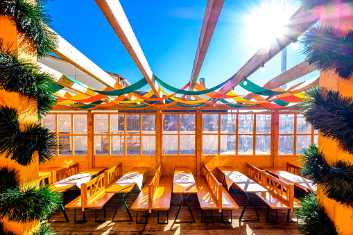 typical bavarian beergarden with wooden benches and tables - photo
