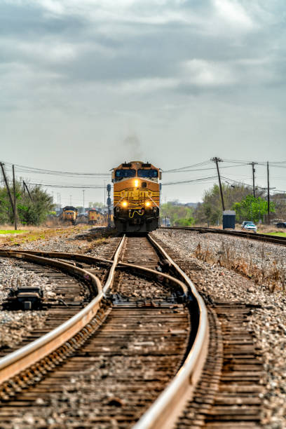 A freight train locomotive approaching downtown Houston, Texas on a cloudy winter afternoon.