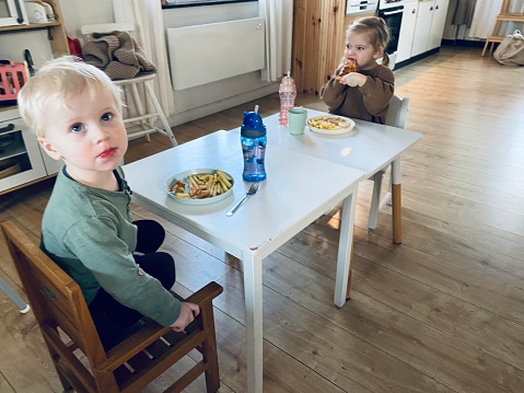 Eating toddler girl and boy having dinner