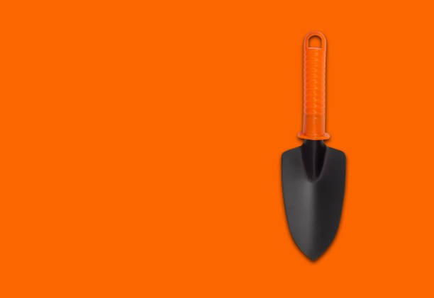 istock Hand plant shovel isolated on orange background 1470056576