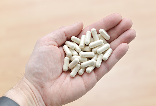 Closeup of health supplements in a man's hand.