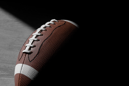 American football leather ball on grey wooden background. Top view. Game equipment horizontal sport theme poster, greeting cards, headers, website and app