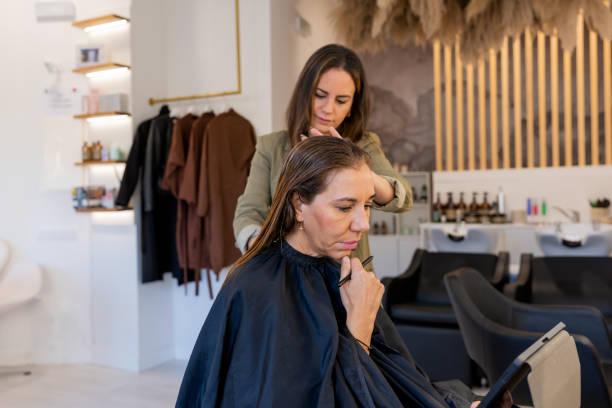 istock Hairdresser combing hair of client using tablet 1470056981