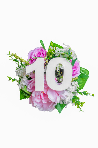 Number ten shape with bunch of flowers isolated over white background. Summer concept. Flat lay. Top view
