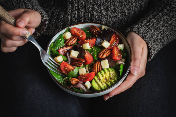 istock Healthy homemade salad with tomatoes, cheese cubes, pecans, avocado, spinach and arugula. 1470059032
