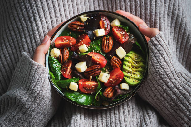 istock Healthy homemade salad with tomatoes, cheese cubes, pecans, avocado, spinach and arugula. 1470059040