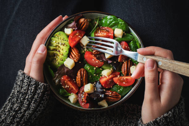 istock Healthy homemade salad with tomatoes, cheese cubes, pecans, avocado, spinach and arugula. 1470059054
