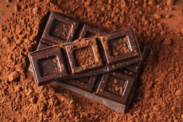 istock Dark and milk chocolate with nuts on a dark background sprinkled with cocoa powder. 1470059075