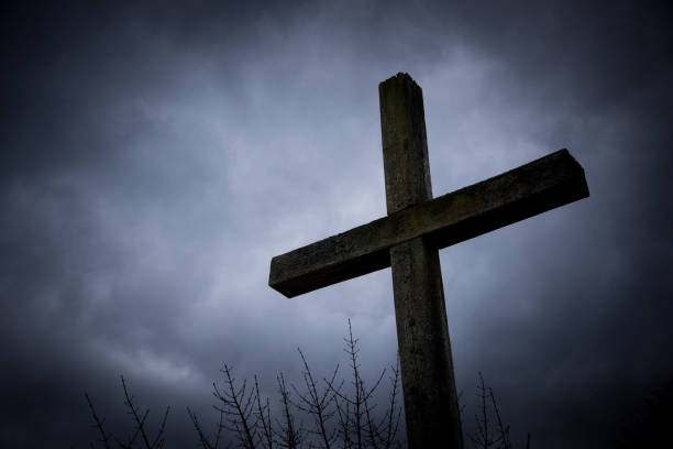 istock Christian wooden cross against  background with dramatic dark clouds and sky 1470060854