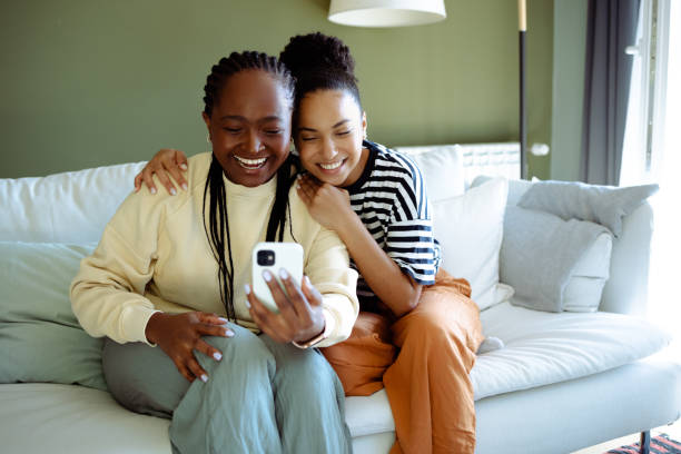 istock Smiling young African-American women using smart phone at home 1470062678