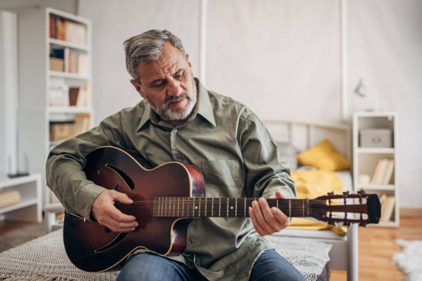 istock A lonely man with a beard enjoys playing the guitar at home 1470065483