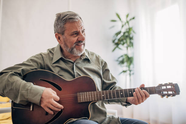 istock A lonely man with a beard enjoys playing the guitar at home 1470065493