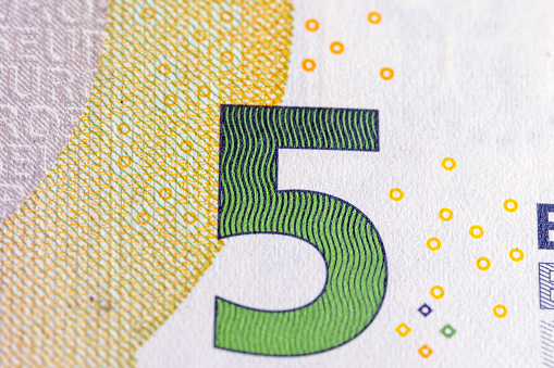 European cash banknotes with a face value of 5 euros close-up , details of a five euro blue paper bill