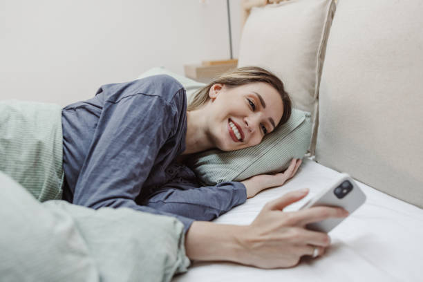 istock Young woman is waking up and using smart phone in bed 1470066772