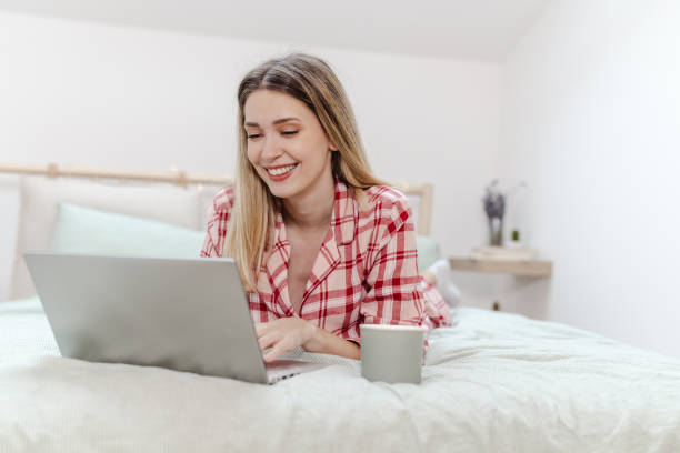 istock Young woman is using laptop in bed 1470066857
