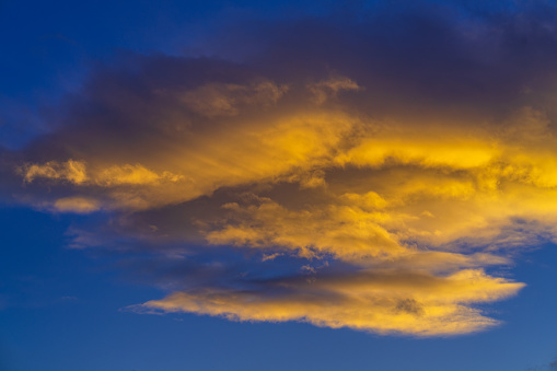 Blue Sky Warm Orange Gold Clouds with Copy Space Background - Sky replacement image with wispy clouds lit at sunset.