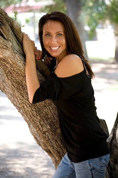 Joven mujer sosteniendo árbol - foto de stock