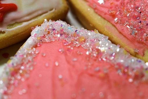Valentine's Day Sugar Cookies Closeup - Macro details of sugar crystals on colorful red, white and pink glazed cookie sweets.