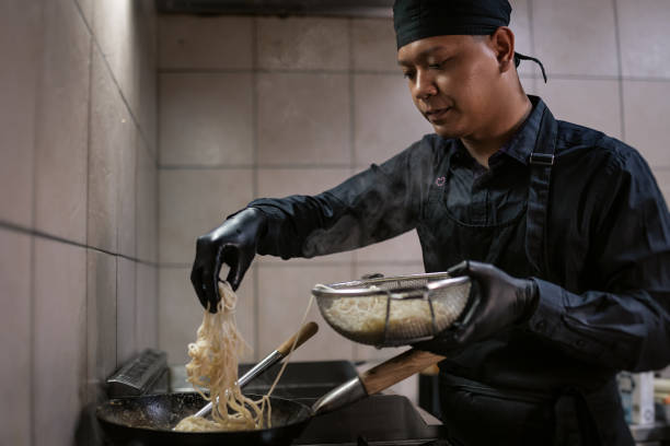 istock A chef in a black uniform prepares a meal. 1470081332