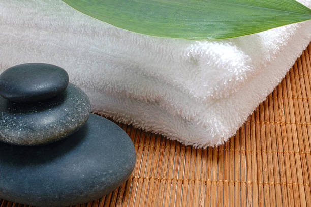 istock pile of hotstones on towel and leaf spa 147008146