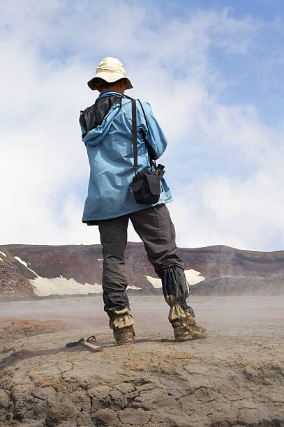 Back of a geologist in a rocky outdoor region Geologist in mountain. Russia. Kamchatka. seismologist stock pictures, royalty-free photos & images