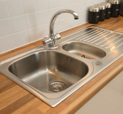 Stainless steel sink with mixer tap recessed into worktop