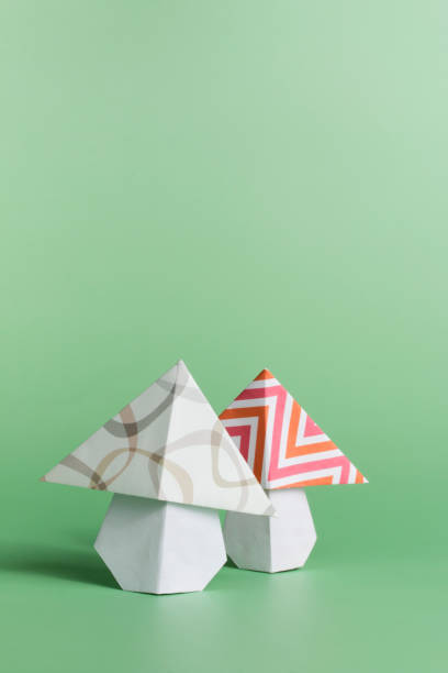 Origami mushroom folded paper art on green background stock photo