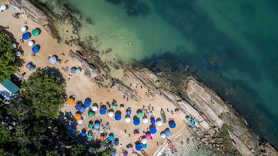 beach umbrellas with bathers in the greenish sea. Bombinhas - Santa Catarina - Brasil
