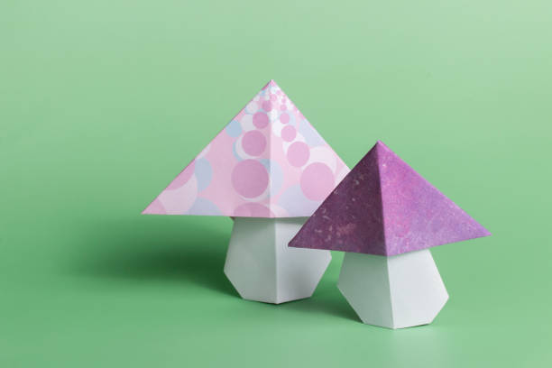 istock Origami mushroom folded paper art on green background 1470094893