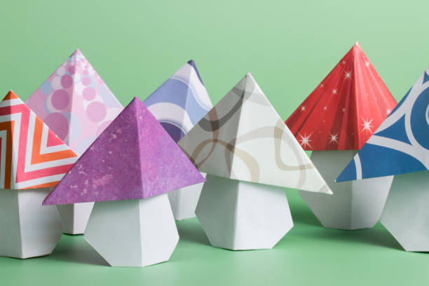 Origami mushroom folded paper art on green background stock photo