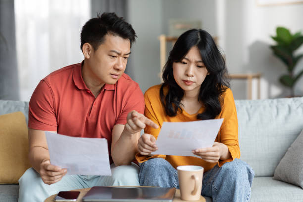istock Confused asian spouses checking bills, home interior 1470095390
