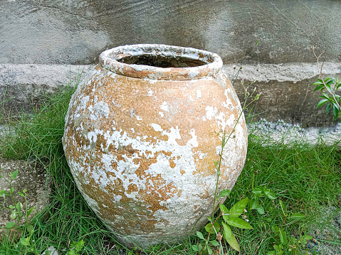 Old clay pot, Pottery clay pot. A large clay pot is sitting in the grass. Old clay jug, Vintage.
