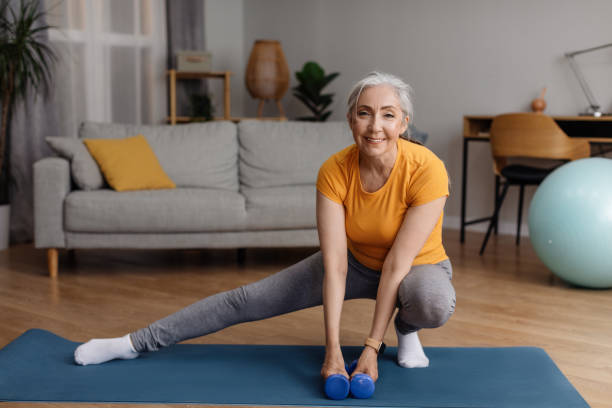 istock Happy senior woman warming up, doing legs stretching exercises while working out at home on fitness mat 1470095654