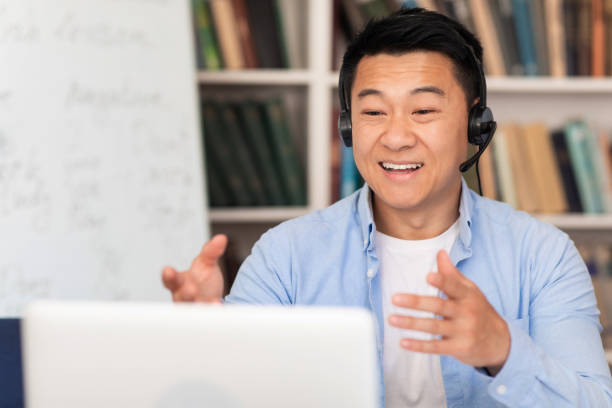 istock Asian Middle Aged Man Video Calling Via Laptop In Classroom 1470095706