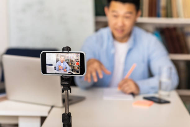 istock Asian Tutor Man Filming Online Lecture Via Smartphone Indoor 1470095708