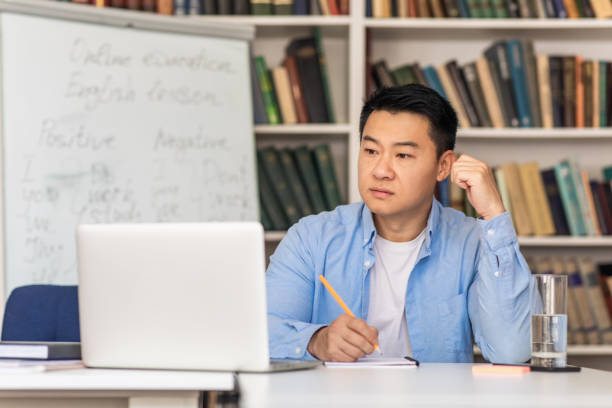 istock Korean Male Teacher Using Laptop Taking Notes Learning Online Indoor 1470095716